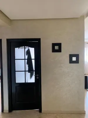 a black door with a dog looking out of it at Modern appartement in Marrakech in Marrakech