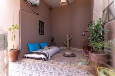 a bed in a courtyard with plants and a cactus at Apartment with panoramic views of Koutoubia in Marrakech