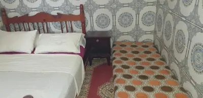 a bedroom with a bed and a wooden headboard at Chez Omar in Marrakech