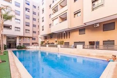 a swimming pool in front of a building at Magnifique appartement 2 chambres à Menara Garden Marrakech in Marrakech