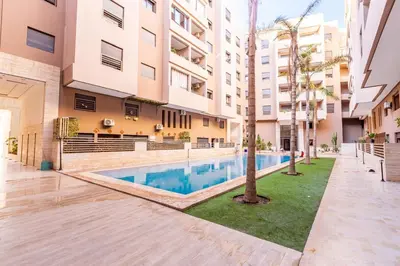 an apartment with a swimming pool in a building at Magnifique appartement 2 chambres à Menara Garden Marrakech in Marrakech