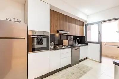 a kitchen with white cabinets and stainless steel appliances at Magnifique appartement 2 chambres à Menara Garden Marrakech in Marrakech