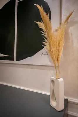 a white vase with feathers in it on a table at Elegant 2BR Modern Prime District in Marrakech in Marrakech