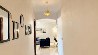 a hallway with a blue chair and a dining room at Cozy apartment in Marrakech