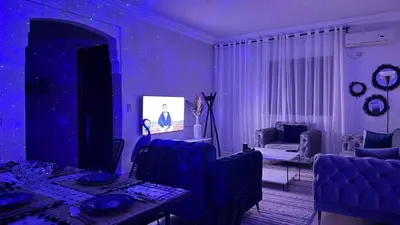a blue living room with a table and chairs at Cozy apartment in Marrakech