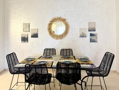 a dining room table with chairs and a mirror at Cozy apartment in Marrakech