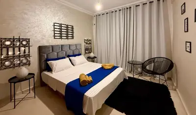a bedroom with a large bed and two chairs at Cozy apartment in Marrakech