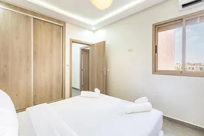 two white beds in a room with a window at Magnifique appartement 2 chambres route du barrage in Marrakech