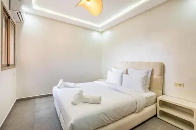 a bedroom with a large bed with white sheets at Magnifique appartement 2 chambres route du barrage in Marrakech