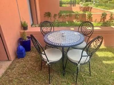 a blue table with four chairs and a vase on it at ART NORIA Private garden - pool view in Marrakech