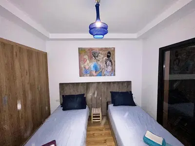 a bedroom with two beds and a blue light at ART NORIA Private garden - pool view in Marrakech