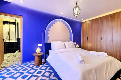 a bedroom with a large bed with a blue wall at Luxury Apartment Retreat in Marrakech in Marrakech