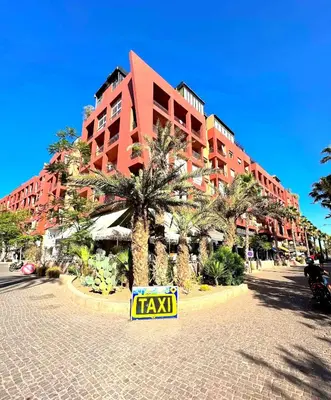 a large red building with a taxi sign in front of it at Luxury Apartment Retreat in Marrakech in Marrakech
