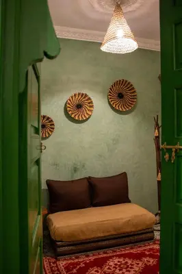 a living room with a couch and four umbrellas on the wall at Riad Eljazouli in Marrakech