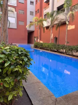 a large blue swimming pool in front of a building at Your Host in Marrakech