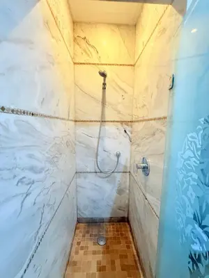 a bathroom with a shower with white marble walls at VILLA 33 - 4 Master Suites, Stylish Moroccan Design & Private Pool in Marrakech