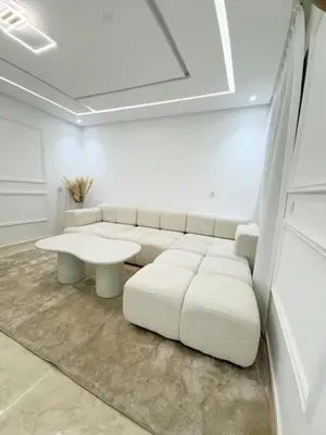 a white living room with a white couch and a table at Appartement de Luxe 3 Chambres avec piscine au centre in Marrakech