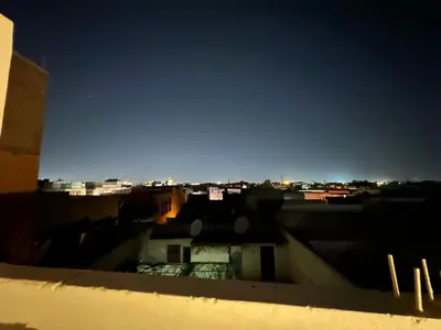 a view of a city at night from a rooftop at Riad Talal in Marrakech