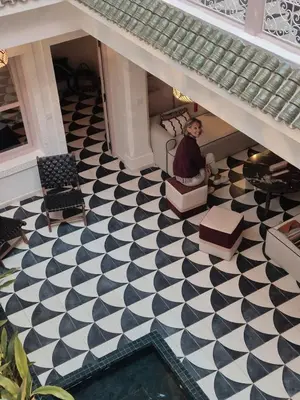 a woman sitting in a chair on a checkered floor at Riad Beltza - 