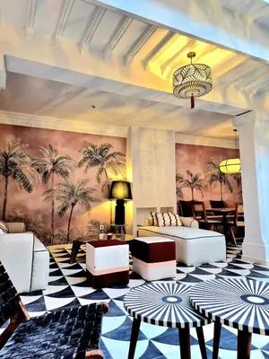a living room with white couches and palm trees at Riad Beltza - 