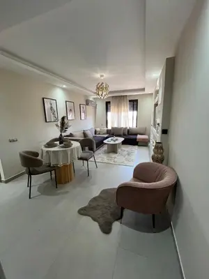 a living room with a couch and a table and chairs at Appart Chic and Cosy, proche Gueliz in Marrakech
