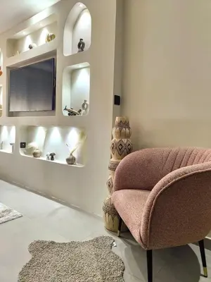 a living room with a chair and a television at Appart Chic and Cosy, proche Gueliz in Marrakech