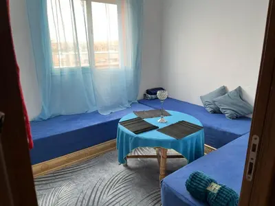a room with two beds and a table and a window at Marrakech in Marrakech