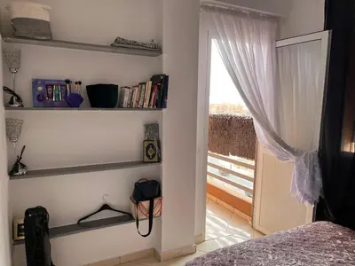 a bedroom with a bed and bookshelves and a window at Marrakech in Marrakech