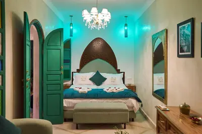 a bedroom with a bed with a green door at Riad Lia ou Lik in Marrakech