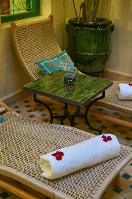 a wicker chair with a table with a towel on it at Riad Lia ou Lik in Marrakech
