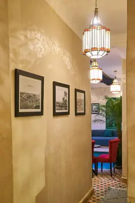 a hallway with a chandelier and a table and chairs at Riad Lia ou Lik in Marrakech
