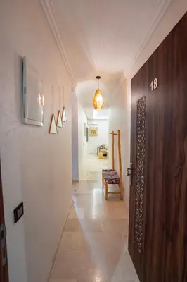 a hallway with a wooden door and a room at Gueliz Central Apartment with Pool and Parking in Marrakech
