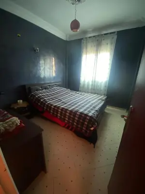a bedroom with a bed with a plaid blanket and a window at Marrakech house Your Haven of Peace in Marrakech in Marrakech