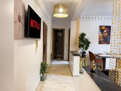 a hallway with a tv on the wall and a table at Appartement privé au cœur de Marrakech in Marrakech