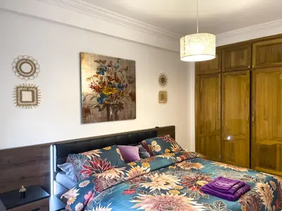 a bedroom with a bed with a colorful blanket at Appartement privé au cœur de Marrakech in Marrakech