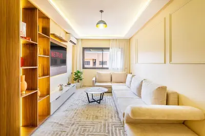 a living room with a couch and a table at Pool views 2BR family apartment in Marrakech