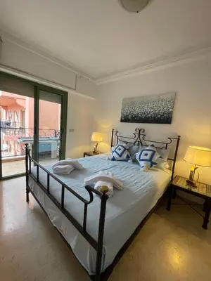 a bedroom with a large bed with blue pillows at Majorelle Appartement - Balcony and Netflix in Marrakech