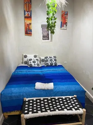 a bedroom with a blue bed in a room at Amber in Marrakech
