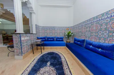 a blue couch in a living room with wallpaper at Riad Dahab in Marrakech