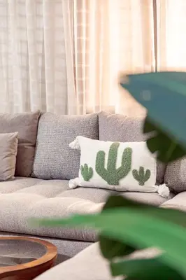 a living room with a couch with a cactus pillow at Appartement confortable au cœur de Gueliz in Marrakech