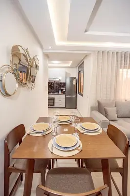 a dining room with a wooden table and chairs at Appartement confortable au cœur de Gueliz in Marrakech