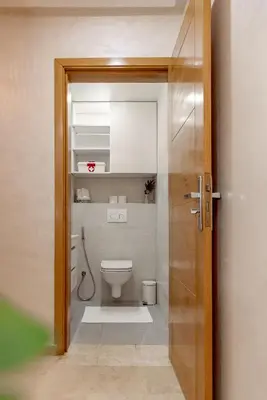 a bathroom with a toilet and a door open at Appartement confortable au cœur de Gueliz in Marrakech