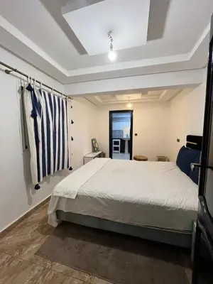 a bedroom with a bed and a window at Appart hotel ali in Marrakech
