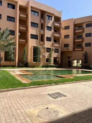 a building with a swimming pool in front of a building at Appartement prestige gueliz in Marrakech