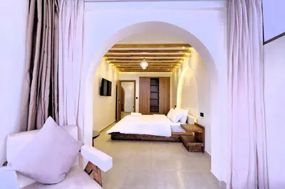 a bedroom with a bed and a chair in a room at Chic & Comfort, Experience Marrakech differently in Marrakech