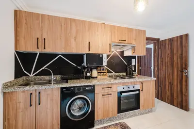 a kitchen with wooden cabinets and a washer and dryer at 4BR Duplex - Jacuzzi - 10 min walk to M Avenue with Parking and Pool in Marrakech