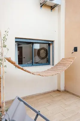 a rope hammock attached to a building with a window at 4BR Duplex - Jacuzzi - 10 min walk to M Avenue with Parking and Pool in Marrakech