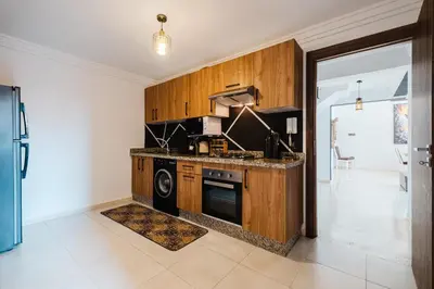 a kitchen with wooden cabinets and a stove at 4BR Duplex - Jacuzzi - 10 min walk to M Avenue with Parking and Pool in Marrakech