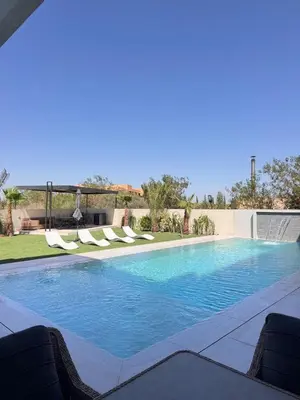 a swimming pool with lounge chairs in a yard at Villa Prestige Zakarya - GOLF AKENZA2 MARRAKECH in Marrakech
