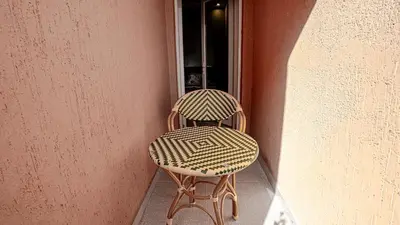 a chair sitting on a porch next to a window at Appartement 2 chambres à Marrakech - Résidence Soulaymane, in Marrakech